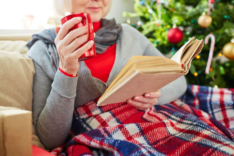 Senior celebrating the holidays in Montgomery Township by reading a seasonal book.