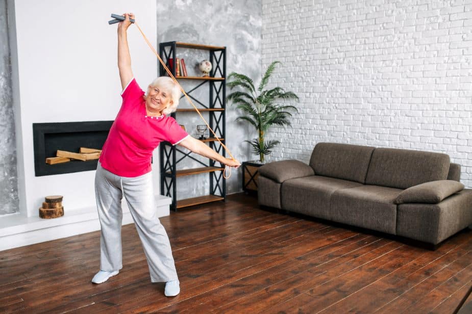 A senior woman doing balance and strength exercises at home.