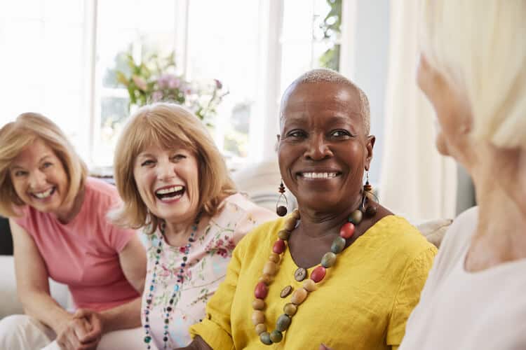 Group of senior female friends smiling and having conversation