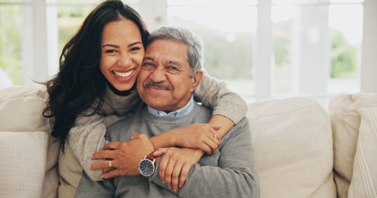 senior man holding adult daughter