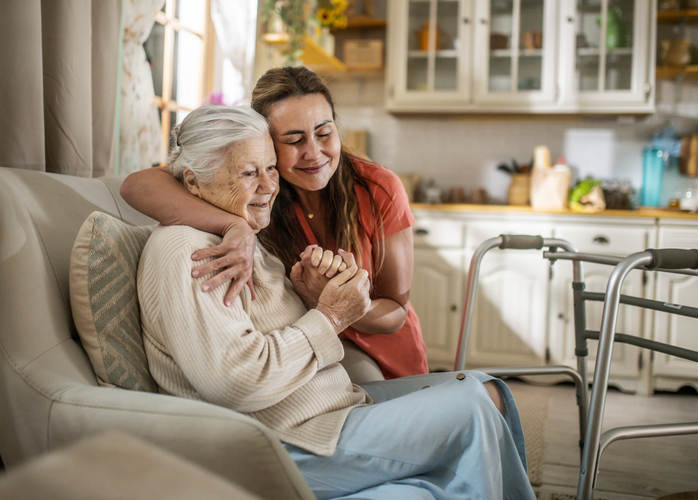 senior woman hugging caregiver