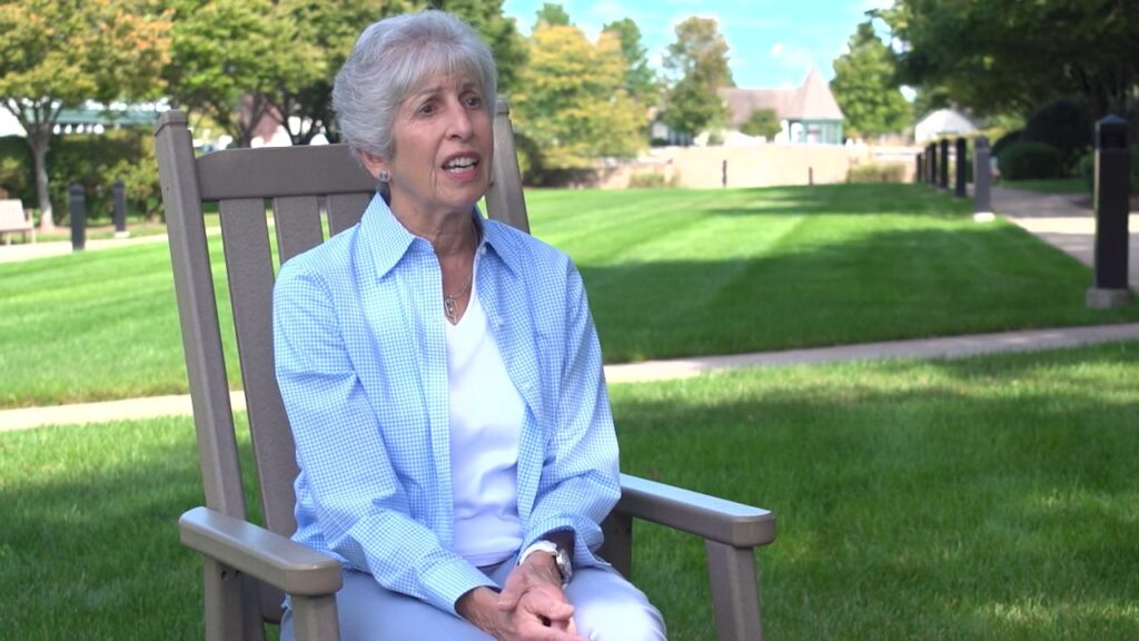 senior woman sitting in wooden chair outside