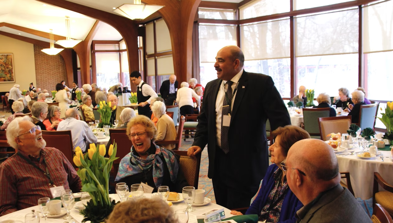 man talking to diners in dining room